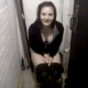 A girl is seen sitting on a toilet. She cuts a fart, and her friend hands her some toilet paper. Not sure if she peed or pooped.